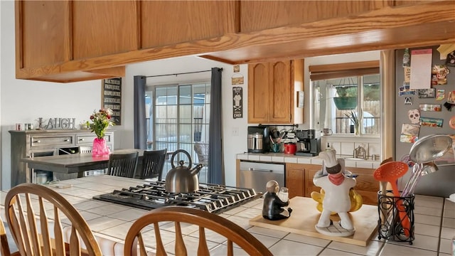 kitchen with tile counters and appliances with stainless steel finishes