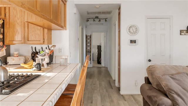 corridor featuring wood finished floors and visible vents