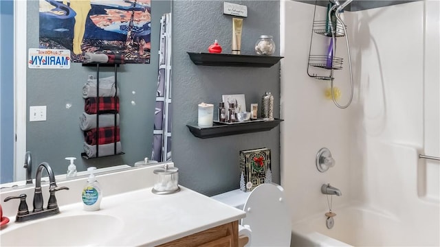 bathroom with toilet, a textured wall, vanity, and shower / bathtub combination