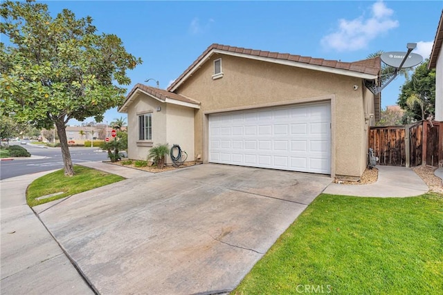 ranch-style home with stucco siding, concrete driveway, fence, a garage, and a front lawn