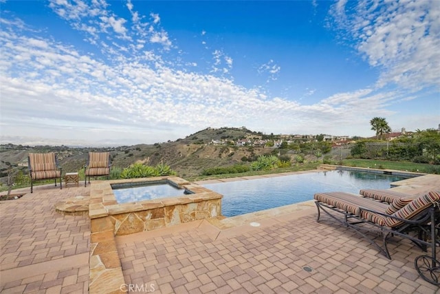 outdoor pool featuring a patio and an in ground hot tub