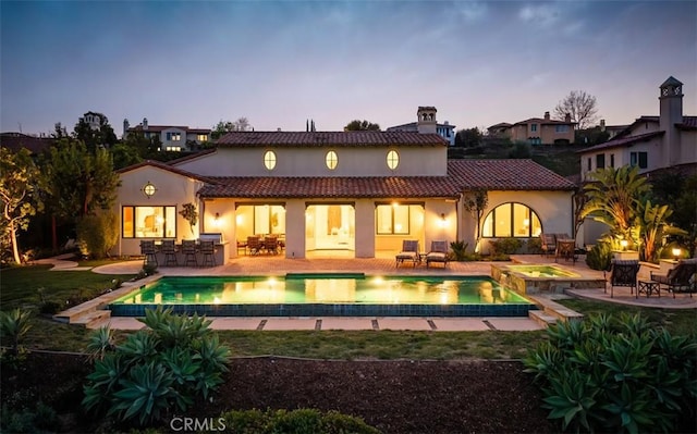 rear view of house featuring a patio area, outdoor dry bar, and a tiled roof