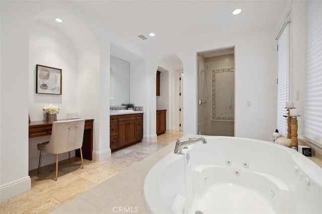 full bath featuring visible vents, vanity, baseboards, a jetted tub, and a stall shower