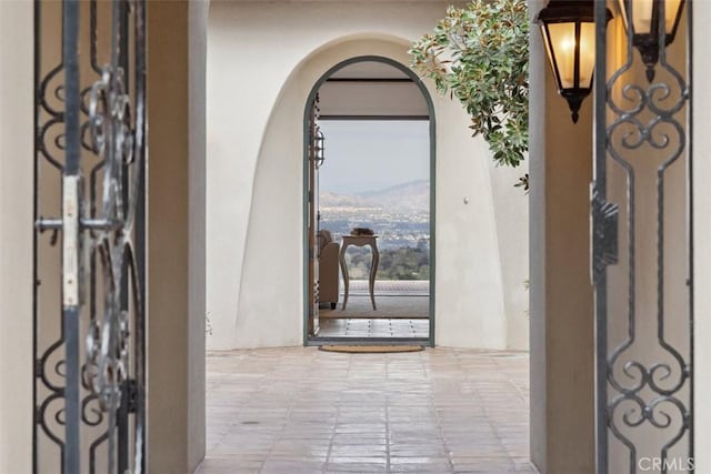 view of exterior entry with a mountain view and stucco siding