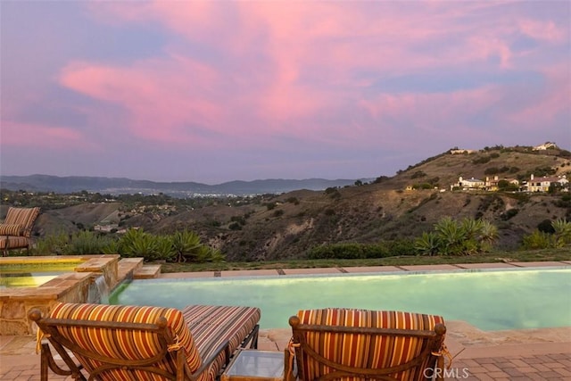 view of swimming pool with a patio and a mountain view