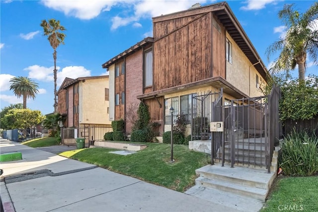 view of front of property featuring stucco siding and a front yard