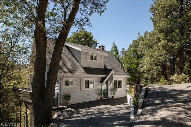 dutch colonial featuring fence and roof with shingles