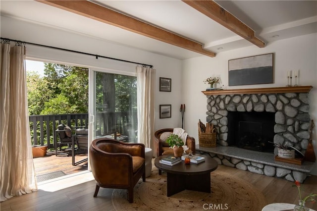 sitting room with a healthy amount of sunlight, a fireplace, beam ceiling, and hardwood / wood-style floors