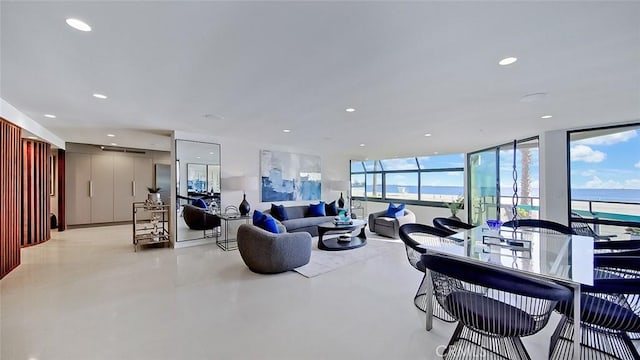 living room with floor to ceiling windows, concrete flooring, and recessed lighting