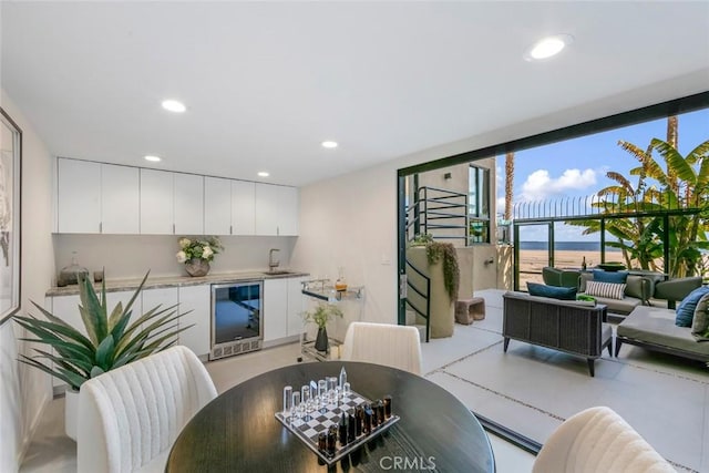 dining space with expansive windows, recessed lighting, and beverage cooler