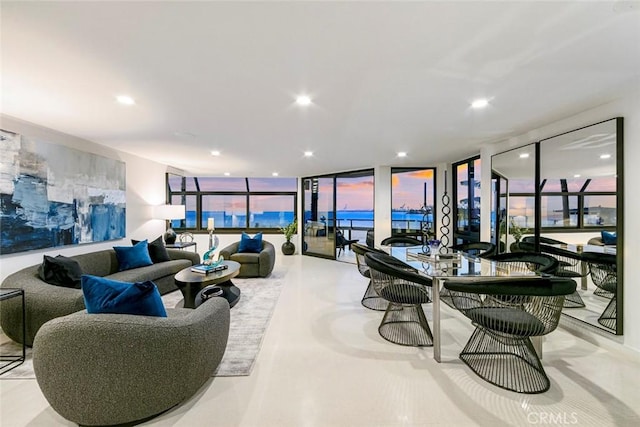 living room with expansive windows, recessed lighting, and concrete floors