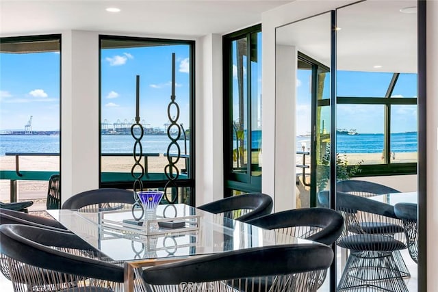 dining space with floor to ceiling windows and a water view