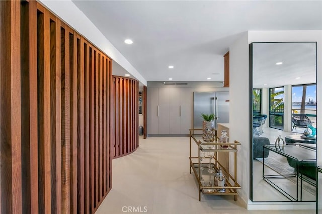 hallway with floor to ceiling windows and recessed lighting