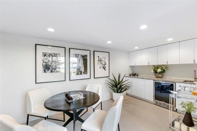 dining room featuring a bar, baseboards, wine cooler, and recessed lighting