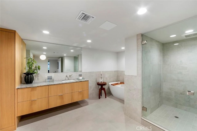 full bathroom featuring tile walls, visible vents, a shower stall, recessed lighting, and vanity