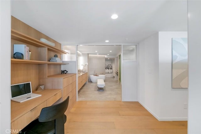 interior space with baseboards, recessed lighting, and light wood-type flooring