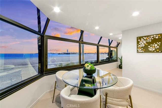 dining space with baseboards, a water view, and recessed lighting