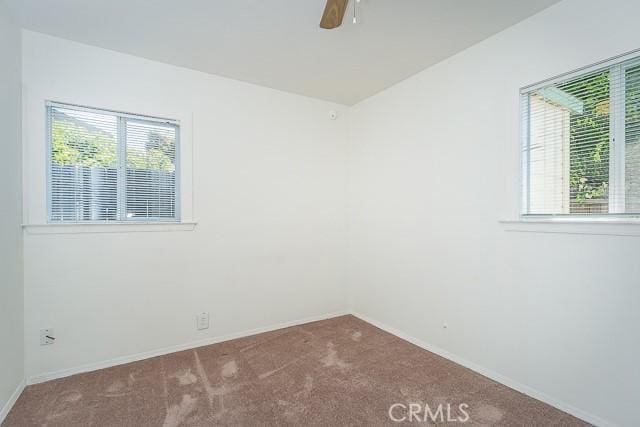 carpeted spare room featuring a wealth of natural light and baseboards