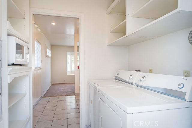 laundry area featuring laundry area, light carpet, independent washer and dryer, and light tile patterned floors