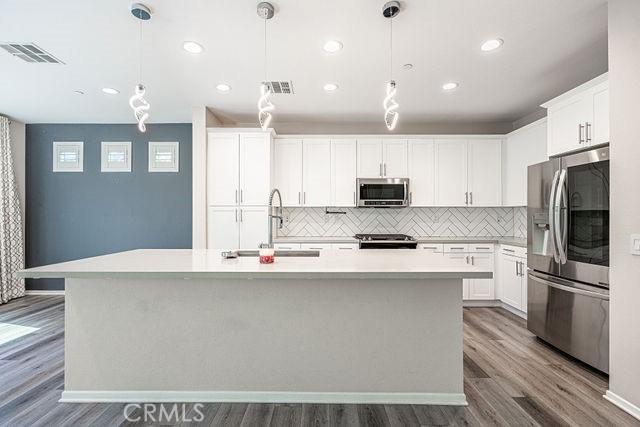 kitchen with visible vents, appliances with stainless steel finishes, light countertops, and a sink