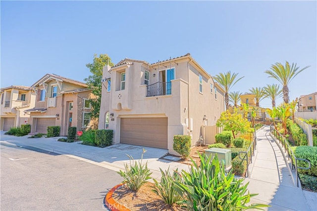 mediterranean / spanish house featuring a residential view, stucco siding, concrete driveway, and a garage