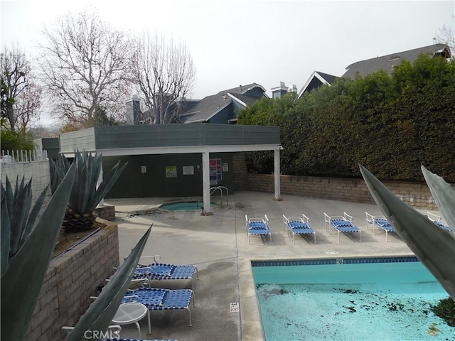 community pool featuring a patio area and fence