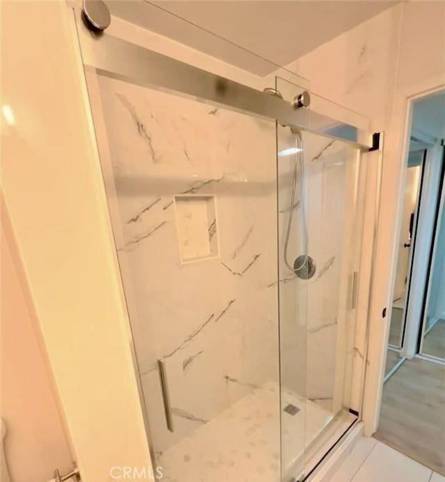 bathroom featuring a marble finish shower