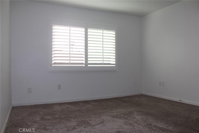 carpeted spare room featuring baseboards