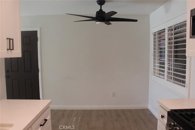 interior space with light wood-type flooring, baseboards, and a ceiling fan