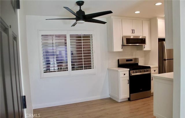 kitchen with stainless steel appliances, white cabinets, and light countertops