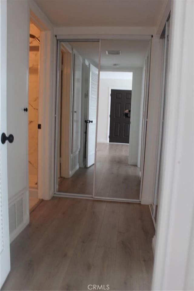 hallway with wood finished floors and visible vents