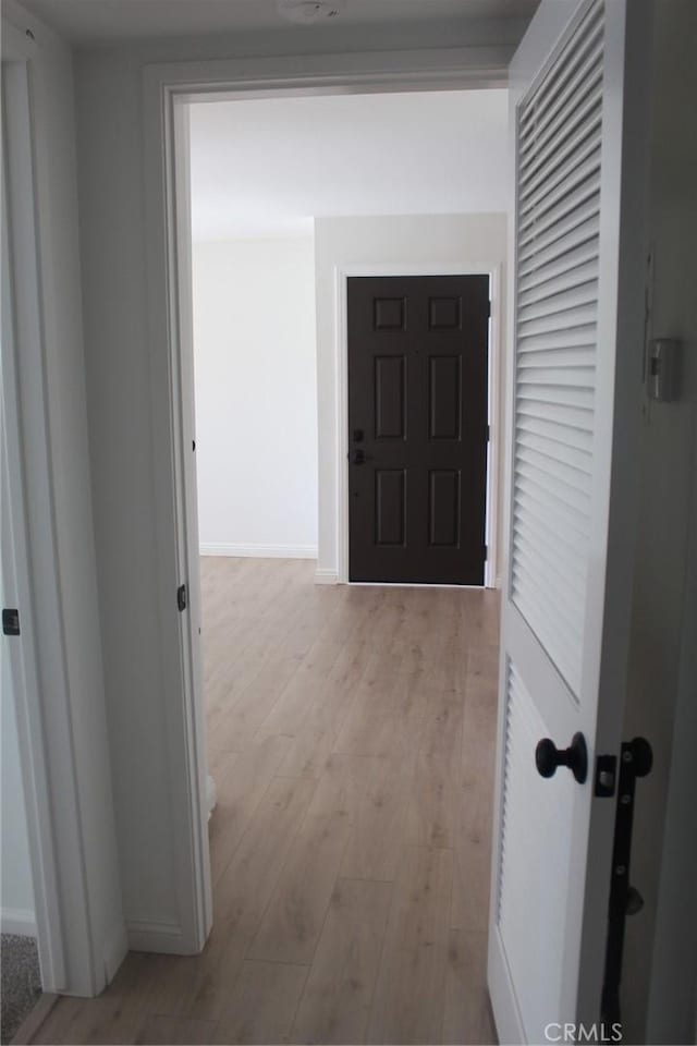 hall with baseboards and wood finished floors