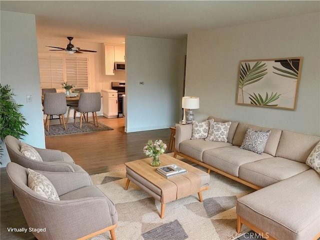 living area featuring ceiling fan, wood finished floors, and baseboards