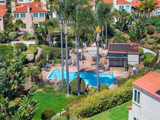 pool featuring a patio area, fence, and a lawn