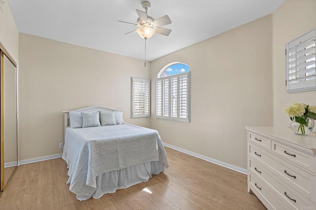 bedroom featuring a ceiling fan, light wood-type flooring, and baseboards