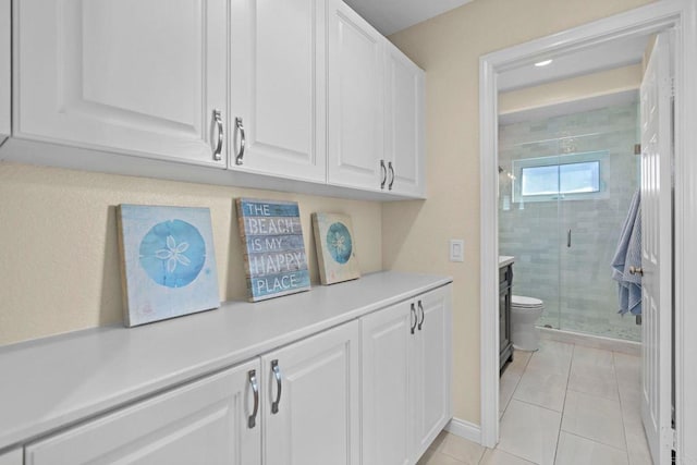 interior space featuring tile patterned flooring, a shower stall, and toilet