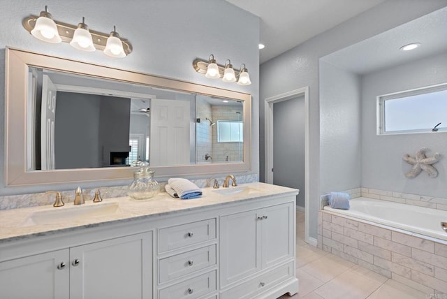 bathroom with double vanity, a shower stall, a sink, and tile patterned floors