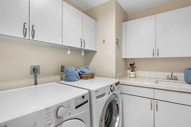 laundry room with cabinet space, independent washer and dryer, and a sink