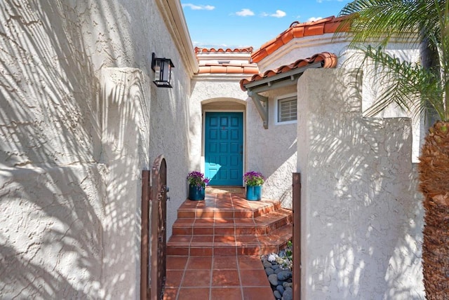 property entrance with a tiled roof and stucco siding