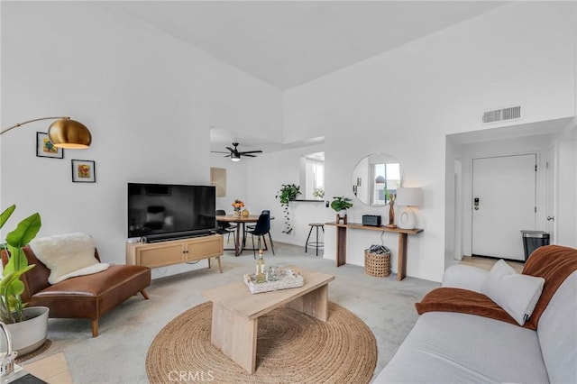 living room with light carpet, high vaulted ceiling, ceiling fan, and visible vents