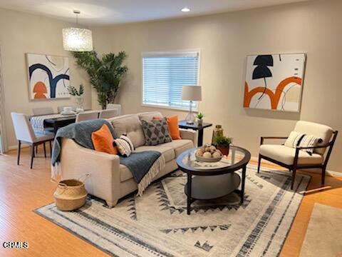 living room with baseboards, wood finished floors, and recessed lighting