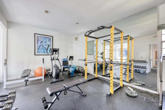 exercise room with visible vents and a textured ceiling