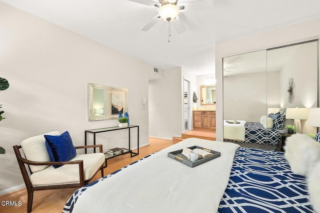 bedroom with baseboards, visible vents, a ceiling fan, wood finished floors, and a closet