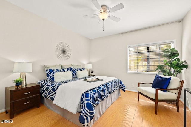 bedroom featuring light wood-style flooring, baseboards, and a ceiling fan