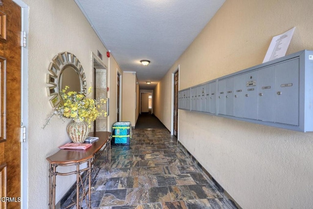 corridor featuring stone finish flooring and mail area