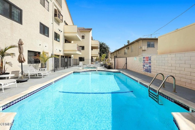 pool with a patio and fence