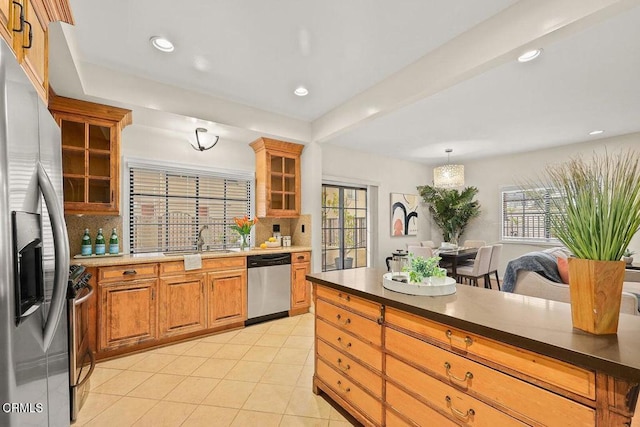 kitchen featuring appliances with stainless steel finishes, plenty of natural light, light tile patterned flooring, and decorative backsplash