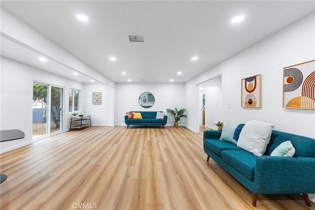 living room featuring light wood-type flooring, baseboards, and recessed lighting