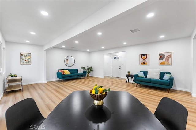 living room with recessed lighting, baseboards, and light wood finished floors