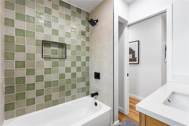 bathroom with vanity, wood finished floors, and shower / bathtub combination